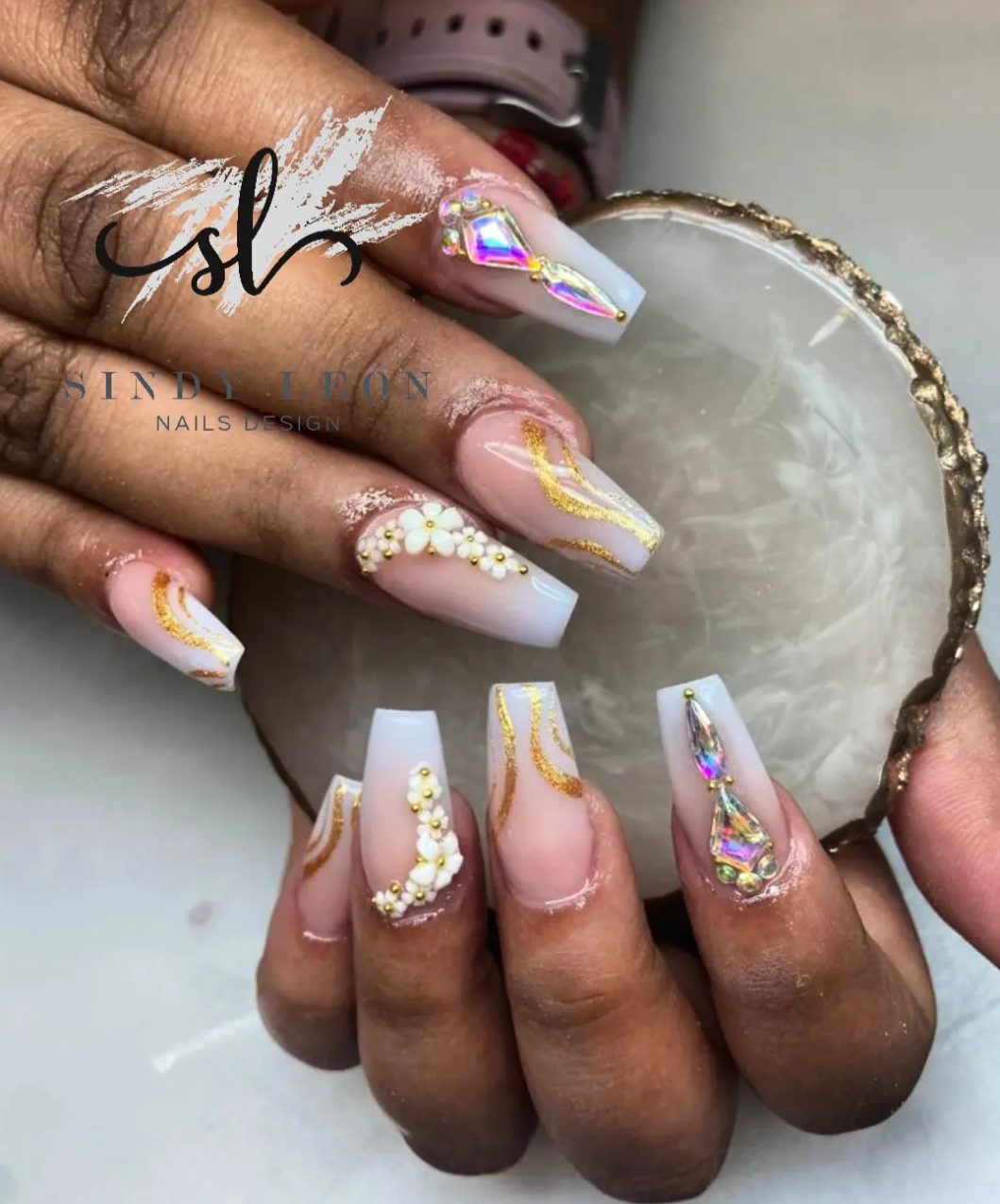 Manicura blanca con pedrería y detalles dorados, trabajo real del estudio
