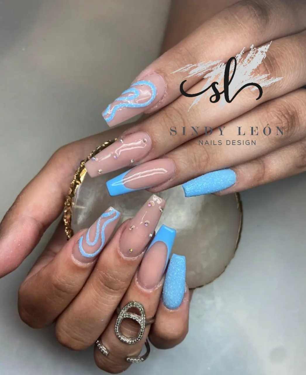 Diseño artístico en azul y nude con pedrería, trabajo real del estudio