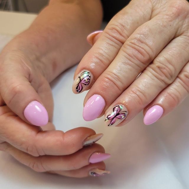 Uñas rosa pastel con mariposas pintadas a mano