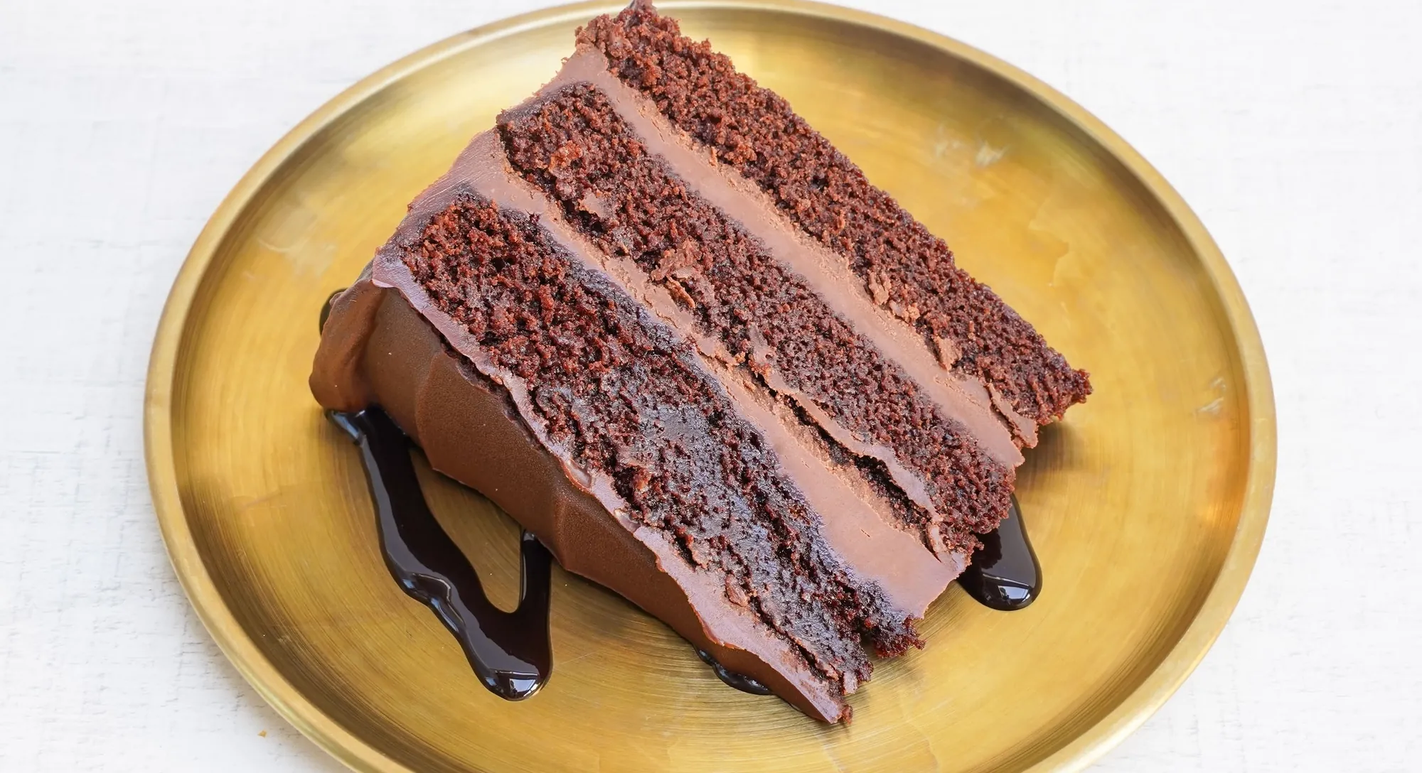Porción de tarta muerte por chocolate sobre un plato dorado