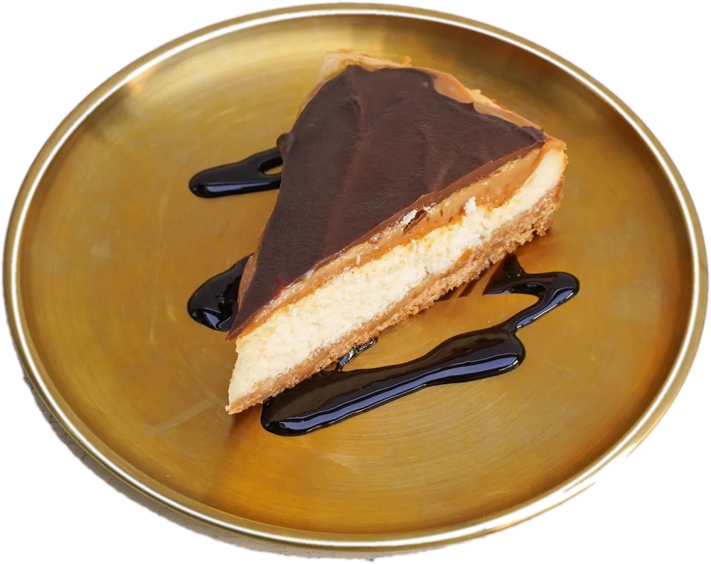 Porción de Cheesecake Snickers en plato dorado