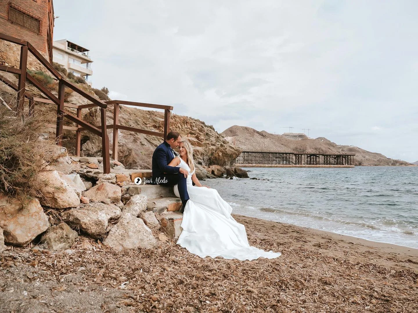 Pareja de novios en un embarcadero junto al mar