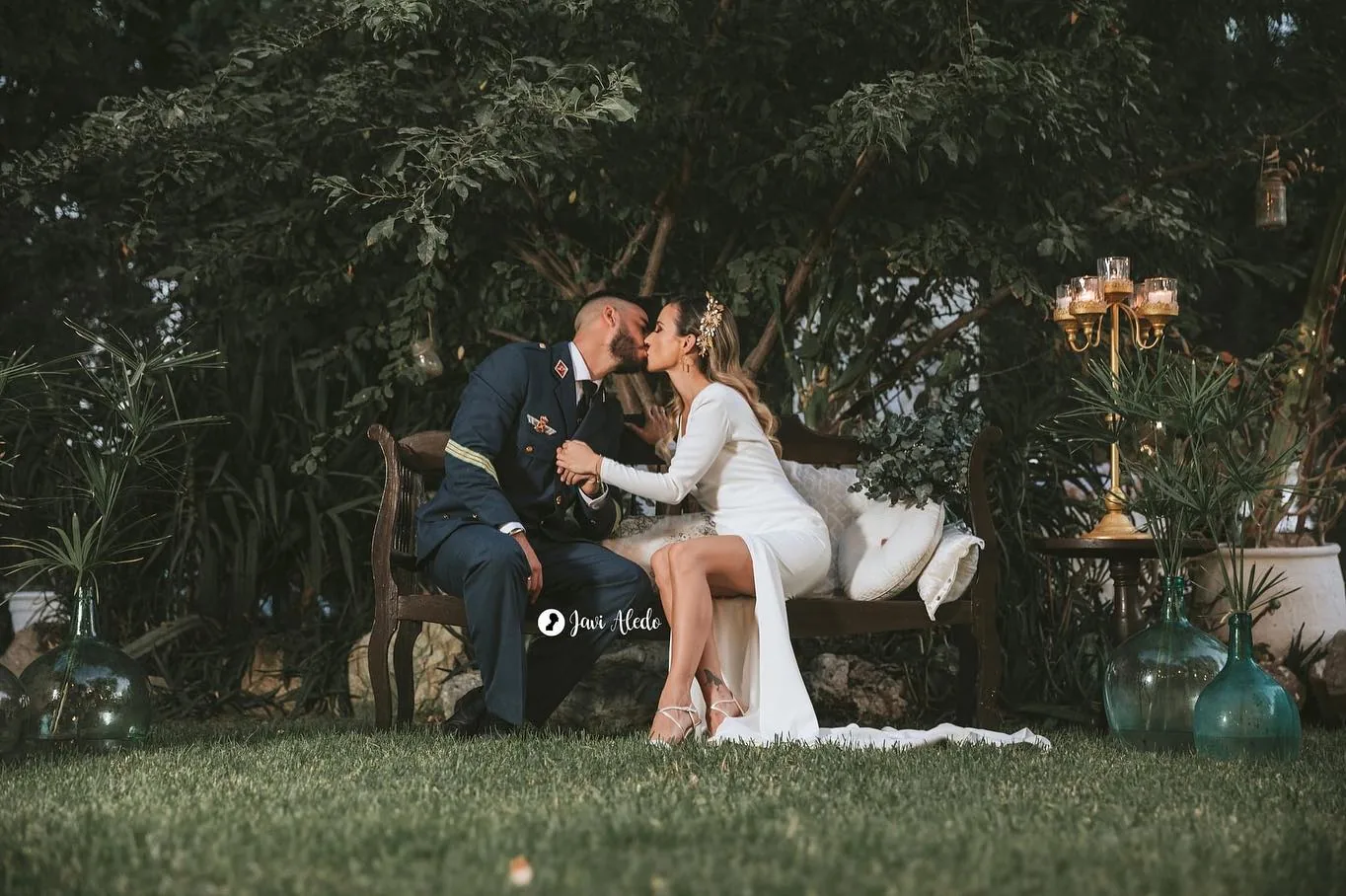Novios sentados en un jardín con lámparas