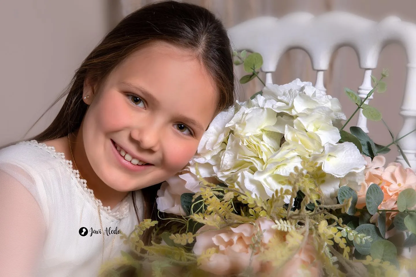 Retrato sonriente de una niña de comunión con flores