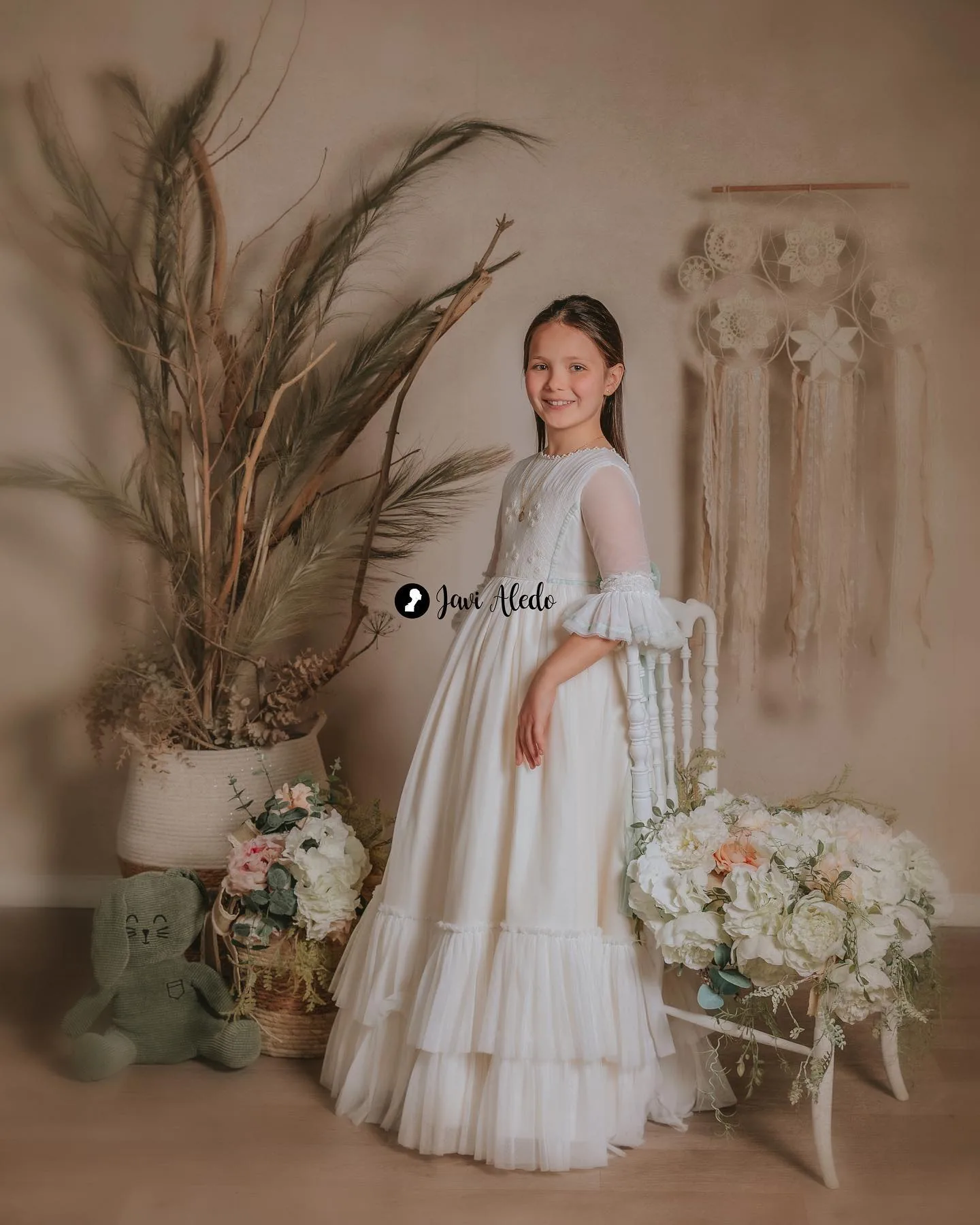 Niña de comunión en un decorado con flores secas