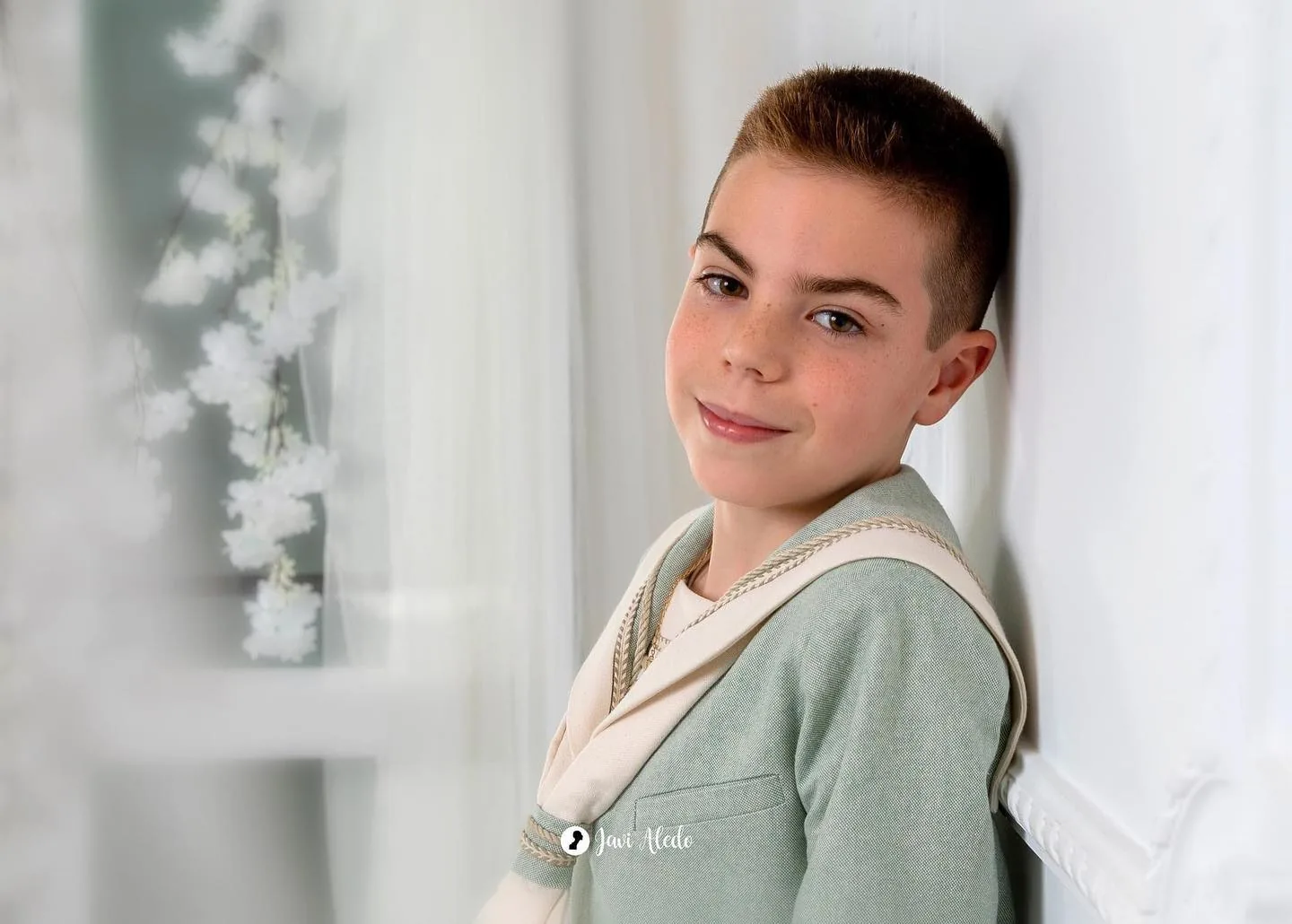 Retrato de un niño de comunión con traje verde agua
