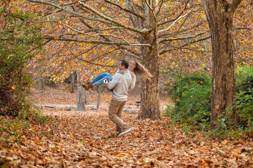Pareja jugando entre hojas de otoño