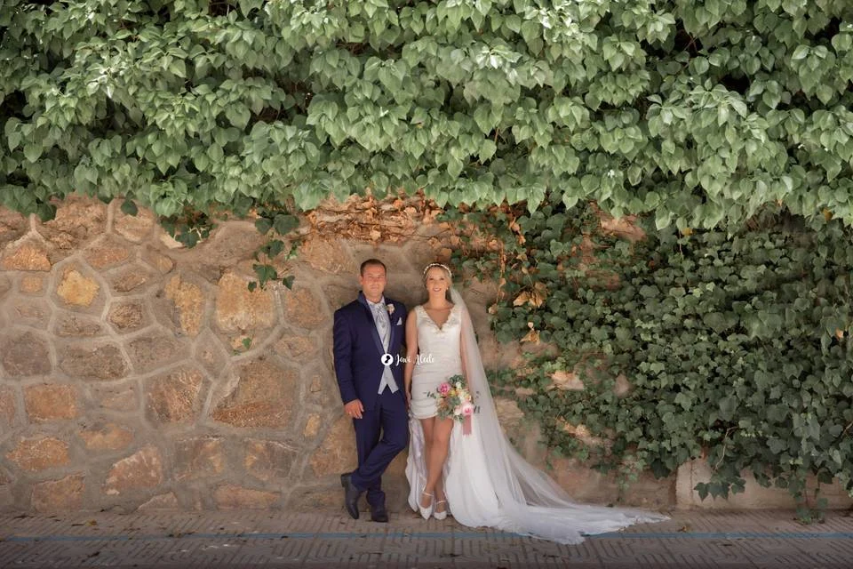 Novios frente a un muro cubierto de hiedra