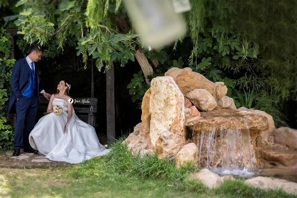 Novios en un jardín con cascada