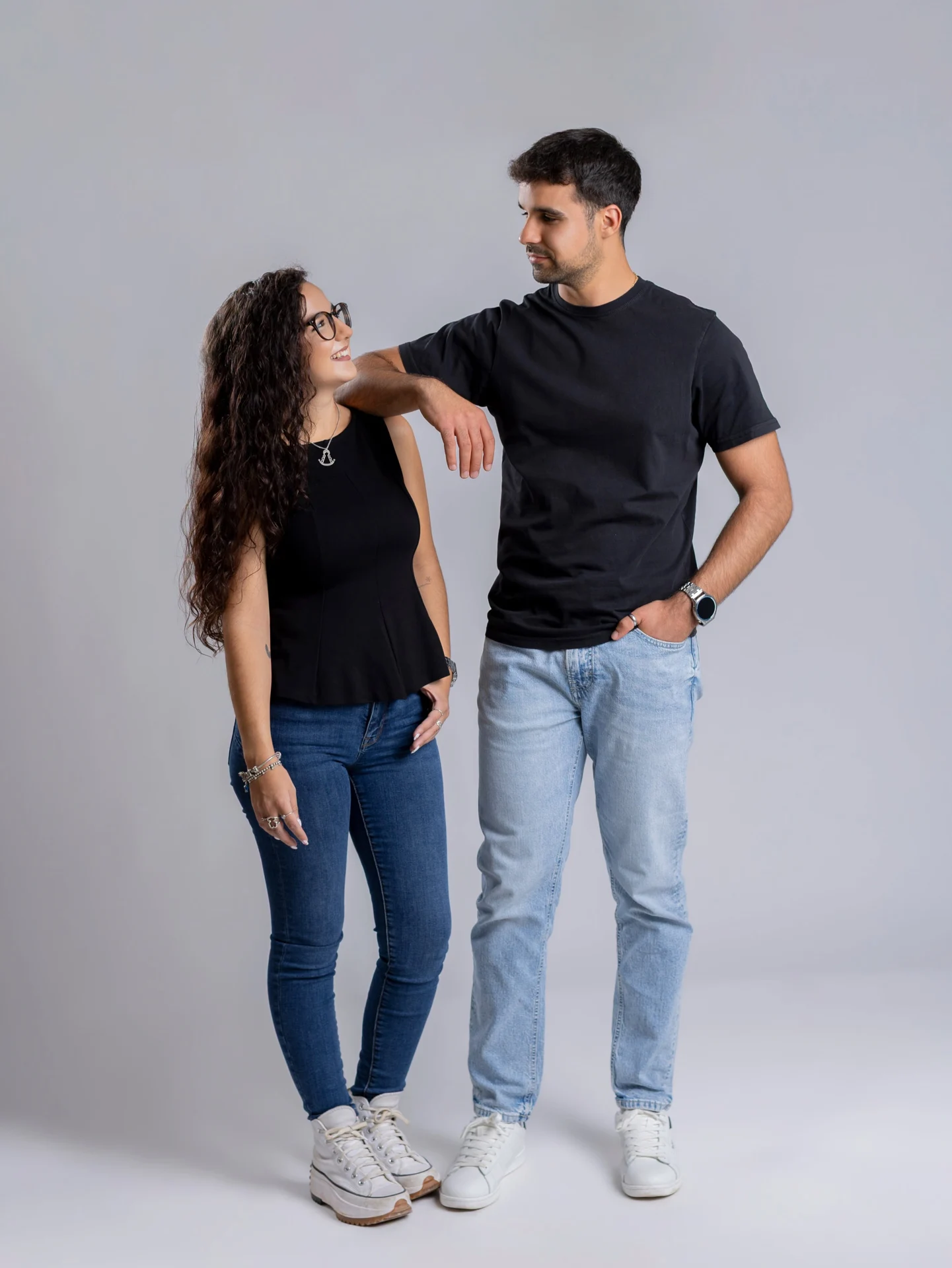 Pareja de jóvenes sobre fondo gris