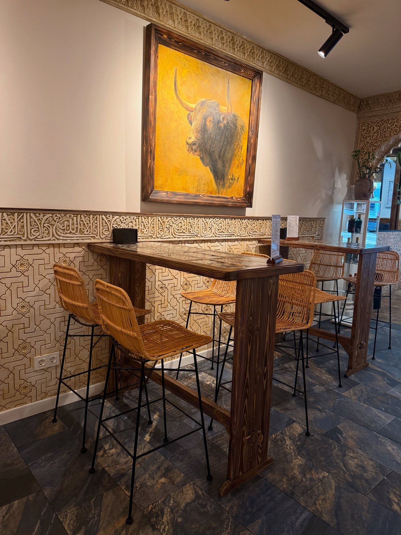 Mesa alta con obra pictórica de un toro al fondo